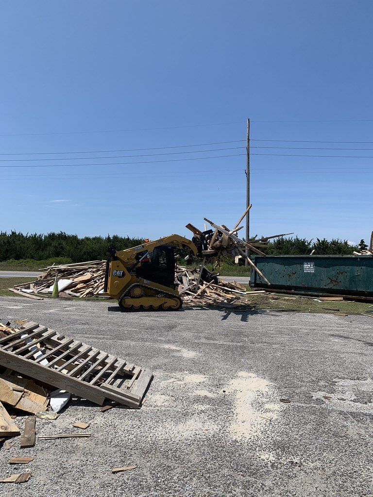 National Park Service staff use heavy equipment to load dumpster with debris — related to construction debris removal